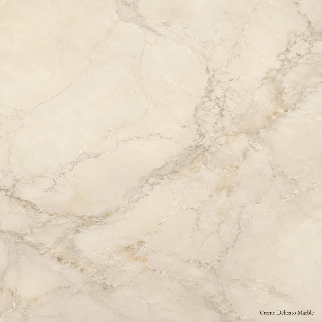 Cremo Delicato Marble with delicate creamy white stone, soft grey ribbons, pale gold accents and a pearly polished finish.