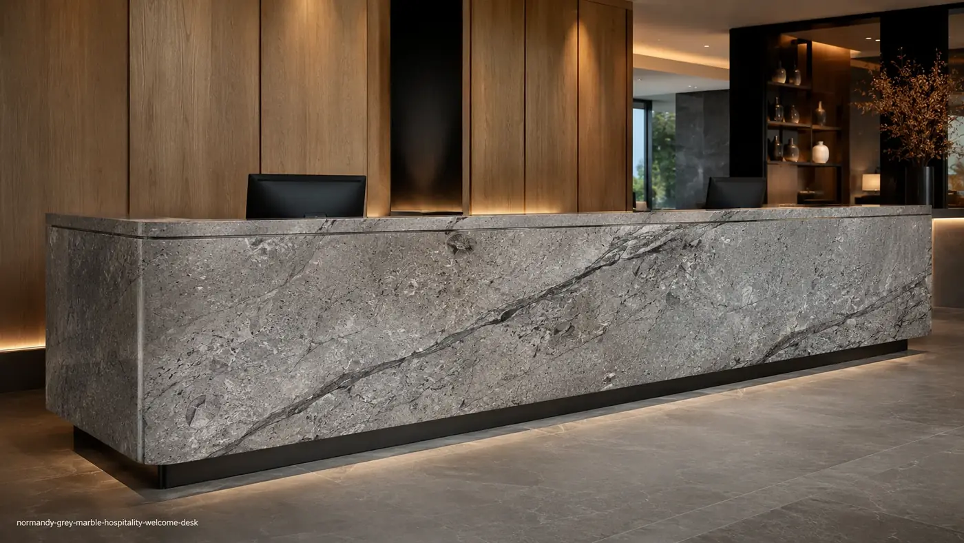 Normandy Grey Marble welcome desk with cement-grey stone, charcoal channels and fossil-like mineral details.