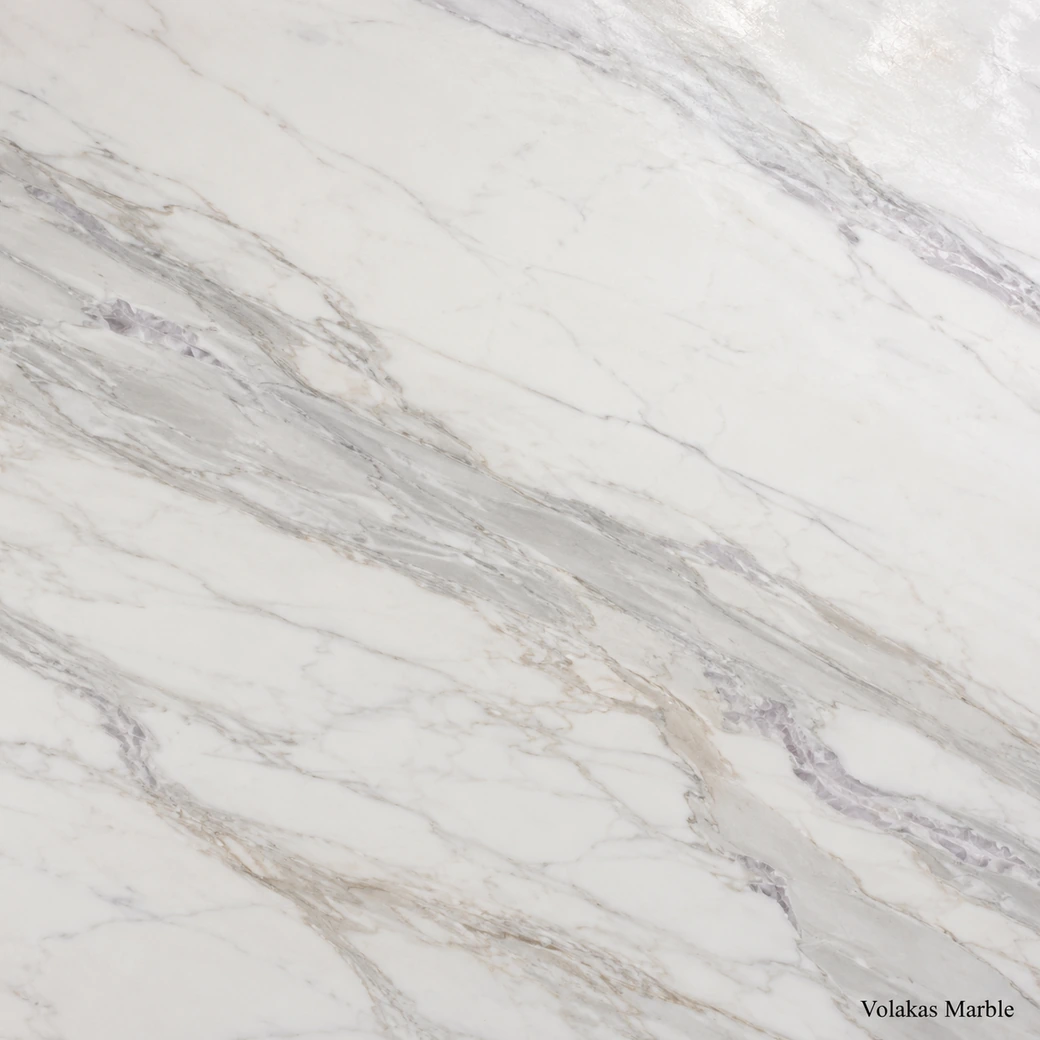 Volakas Marble with soft white clouded stone, grey ribbons, taupe accents, lilac movement and a luminous polished finish.