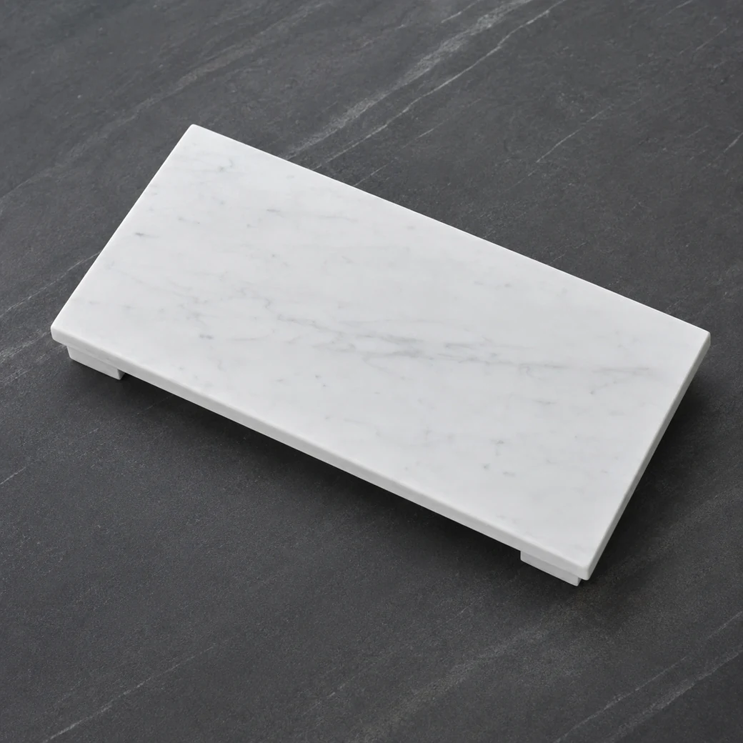 Overhead Bianco Carrara bath platform on charcoal vanity, highlighting soft grey veining and shadows from its raised feet.