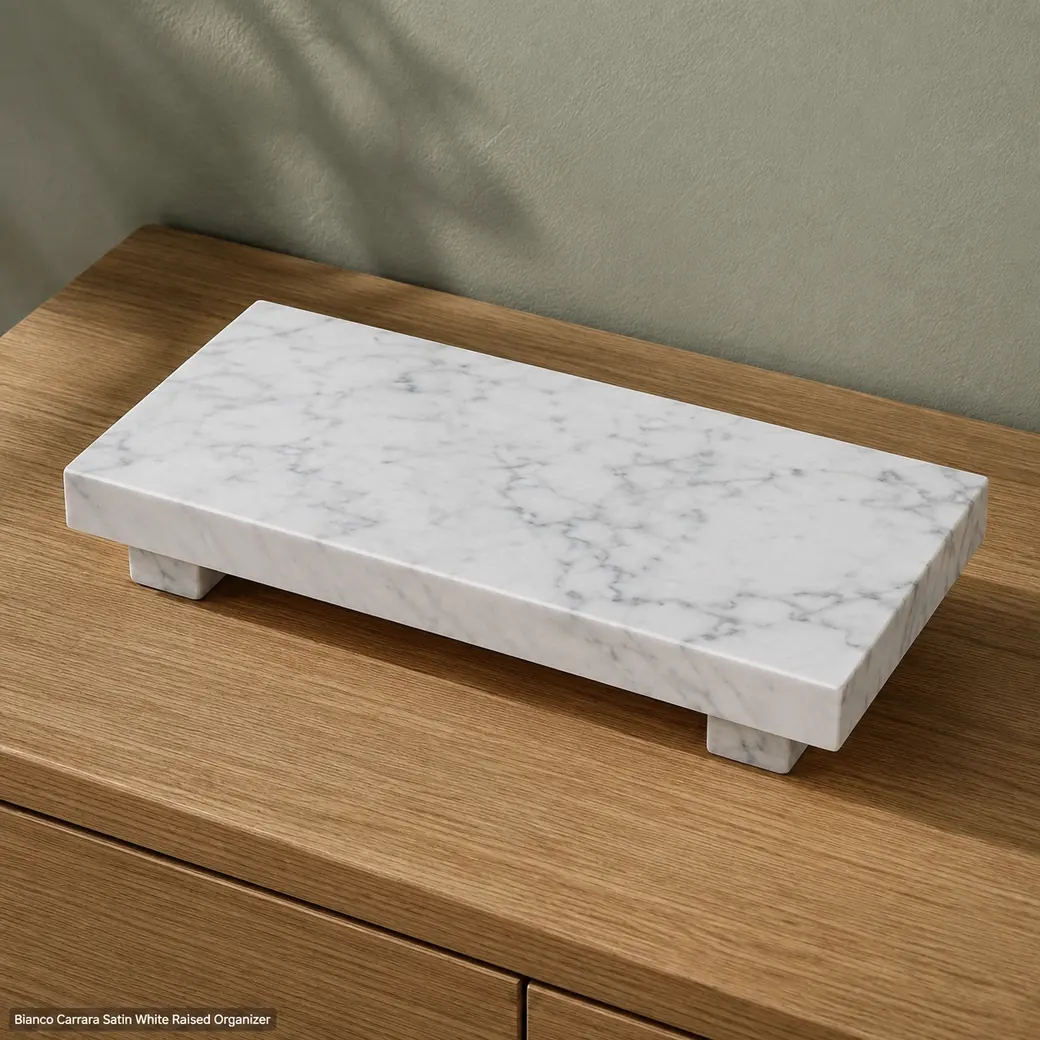 High rear view of Bianco Carrara organizer platform on oak, revealing top veining, raised stone supports and satin edges.