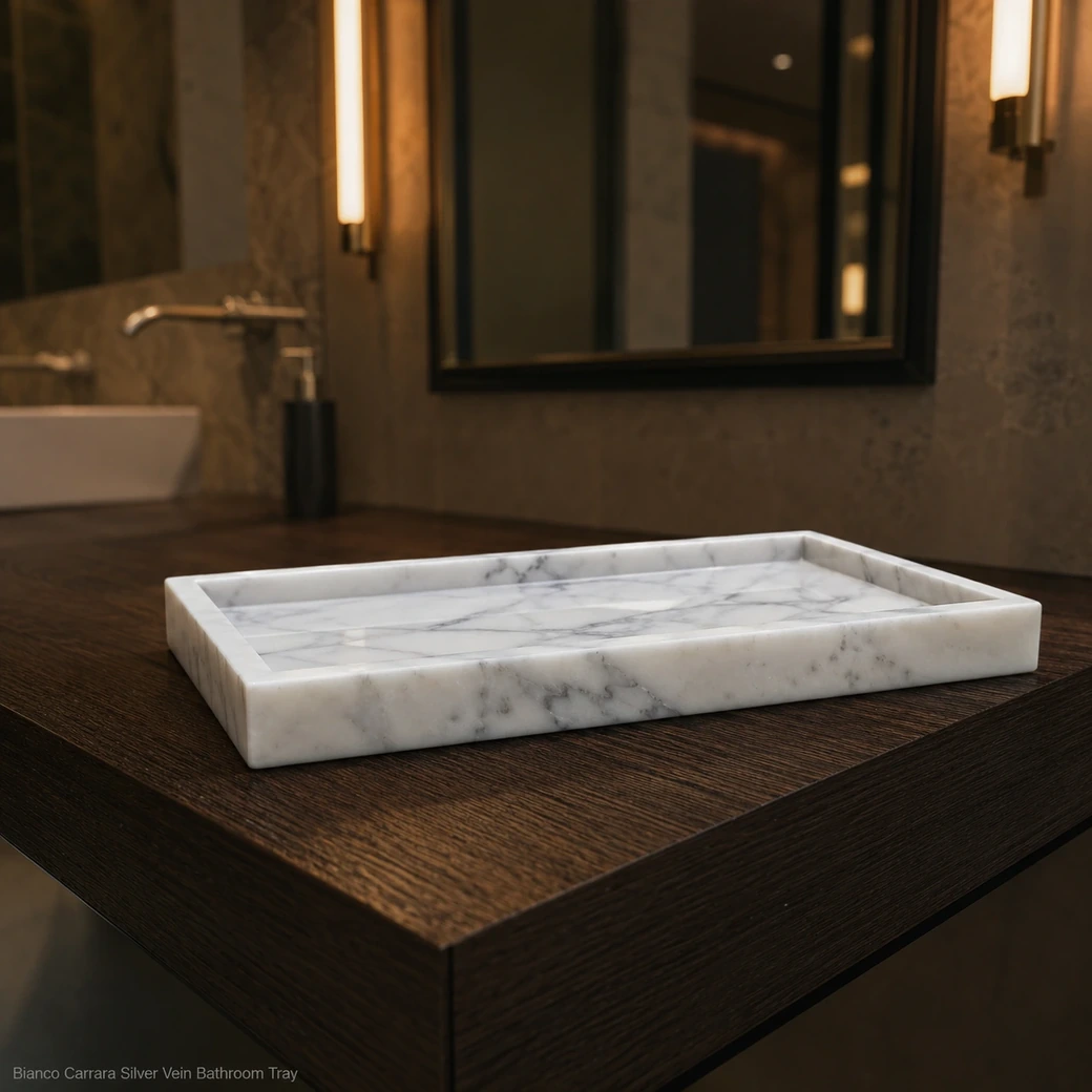 Low-angle Bianco Carrara bathroom tray on dark oak with a shallow rim and silver-grey surface movement.