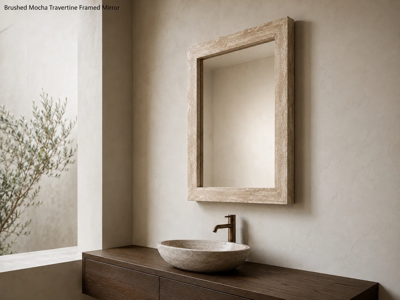 Mocha travertine framed mirror viewed sharply from the side above a floating dark oak vanity