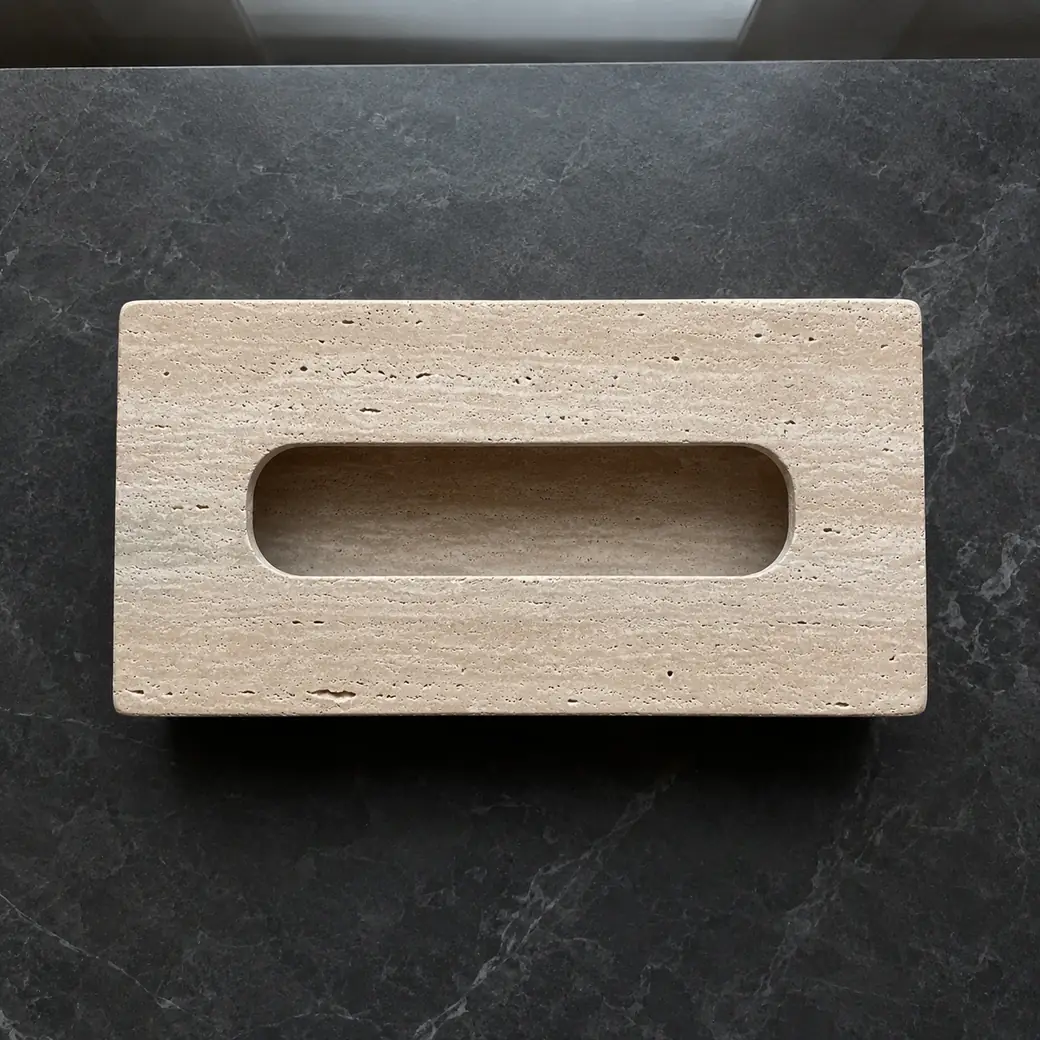 Overhead sandstone beige travertine tissue cover on charcoal stone with brushed pores and top opening.