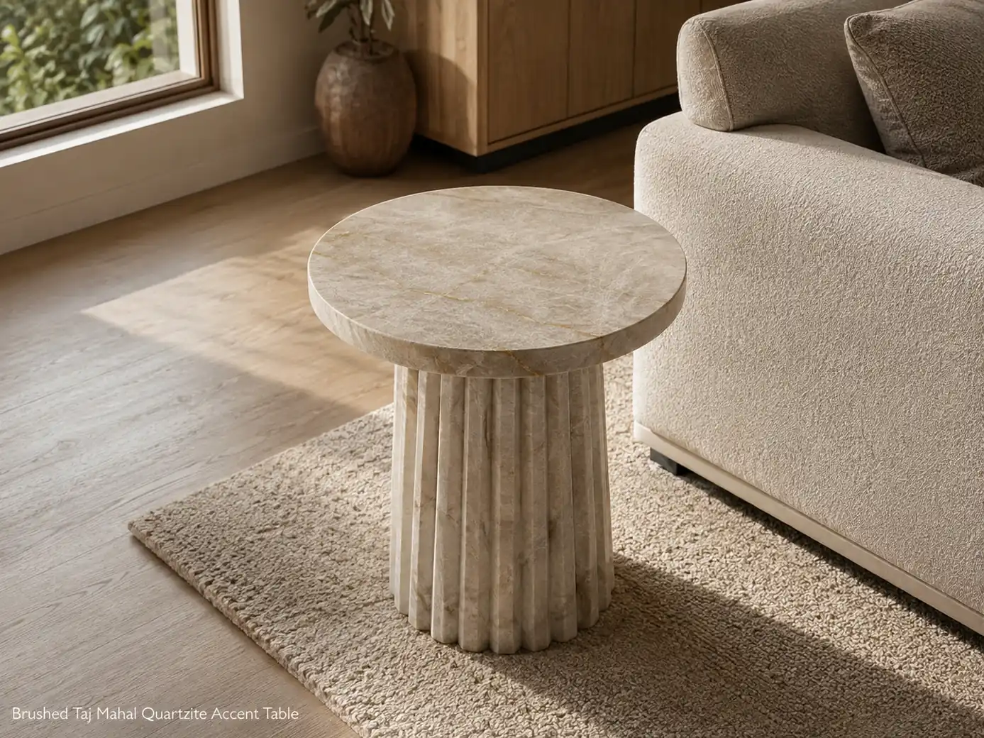 Brushed Taj Mahal quartzite accent table viewed from the rear in a cream-and-oak living room