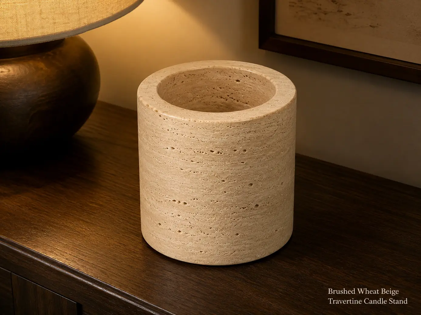 Empty wheat-beige travertine candle stand on dark oak in a softly lit evening interior