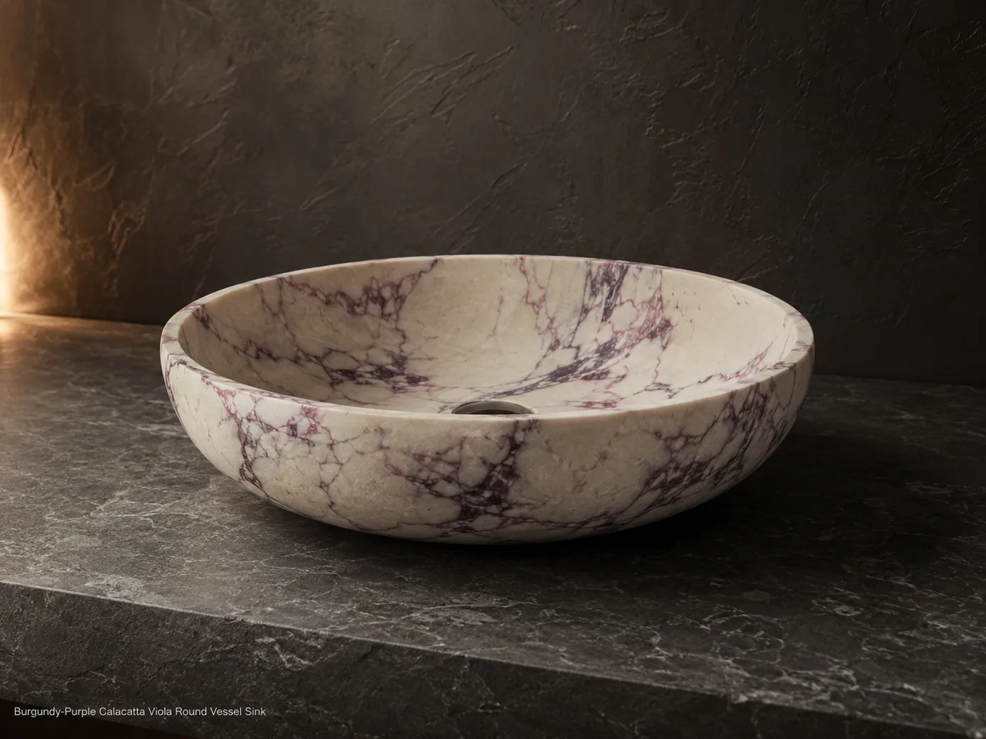 Side-profile Calacatta Viola round vessel sink on charcoal stone, defined by burgundy-purple veins and satin texture.
