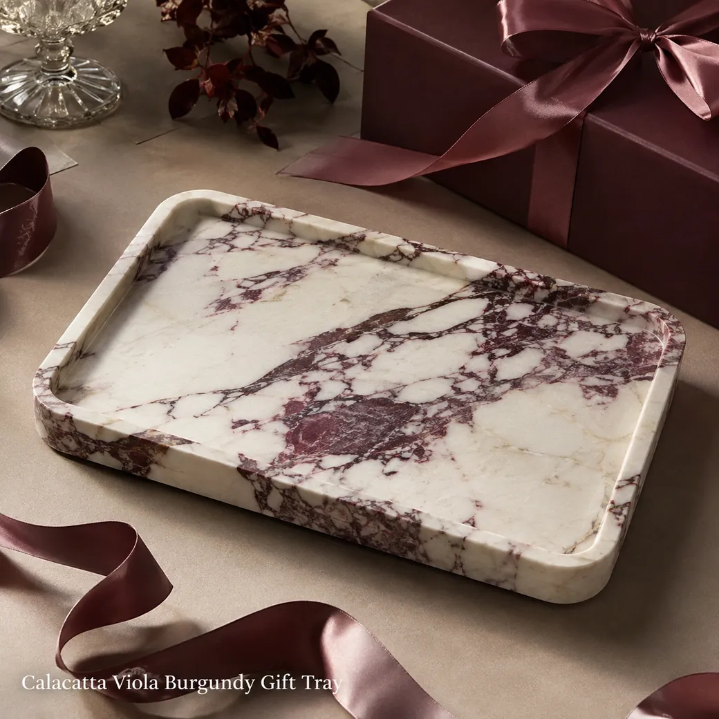 Calacatta Viola gift tray in creamy white marble with plum-burgundy movement and brushed finish.