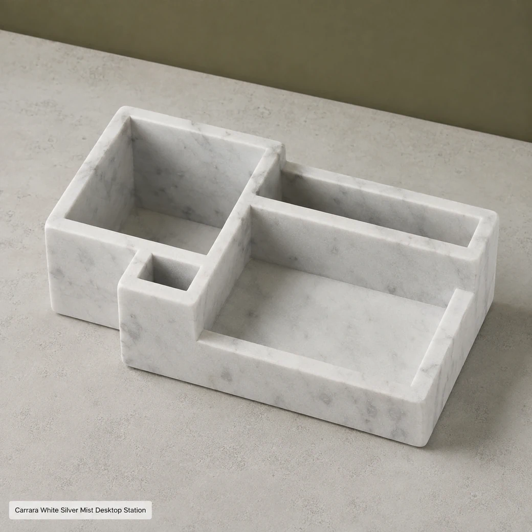 High-angle Carrara desk organizer on pale concrete, clearly showing varied compartment depths and matte silver-grey grain.