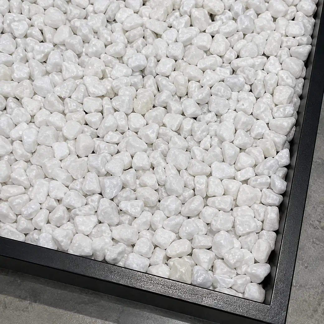 China White marble chips displayed overhead in a black sample drawer with bright crystalline texture.