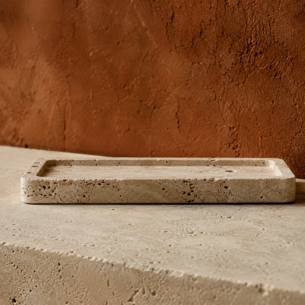 Low-edge desert travertine incense rest on pale stone, highlighting its 2 cm profile, drilled hole and shadowed open pores.