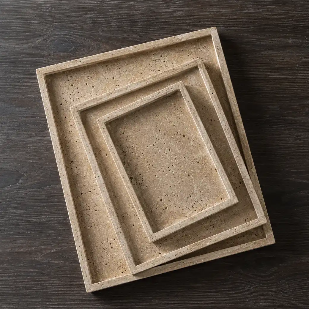 Overhead Classico Travertine tray trio on smoked oak with warm beige pores and thin brushed profiles.