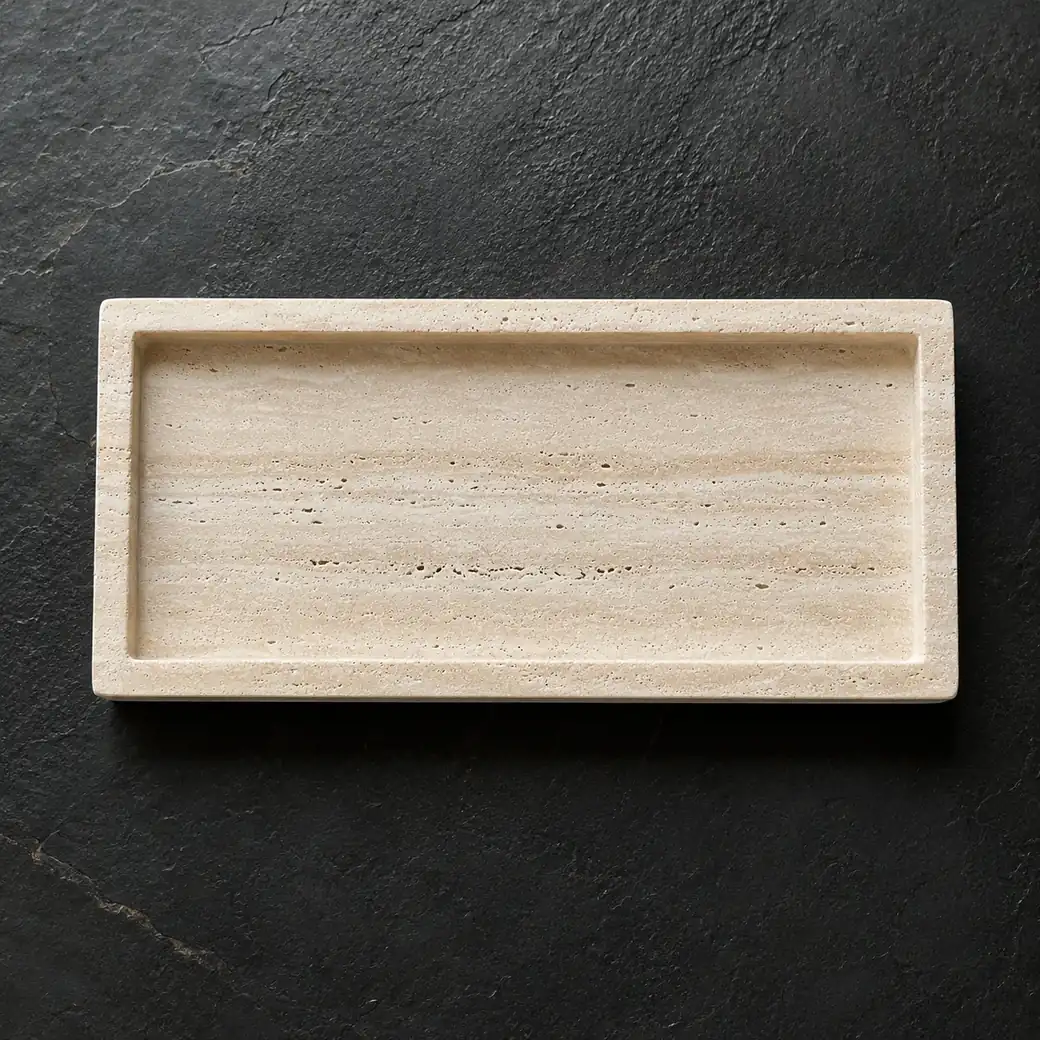 Overhead Classico Travertine bath tray on black basalt with light beige linear banding and brushed finish.