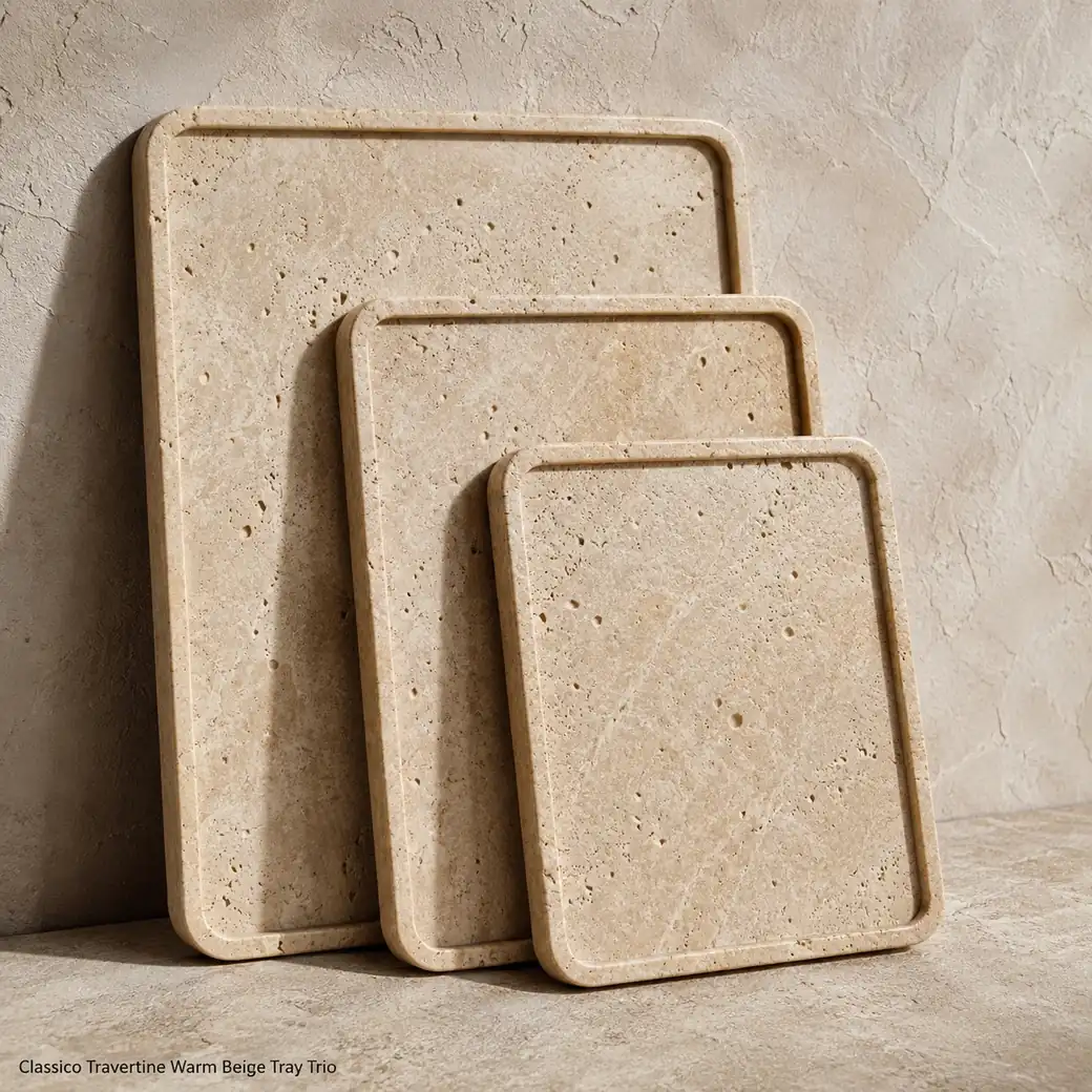 Three warm beige travertine trays standing upright against plaster, with brushed pores and slim layered profiles.