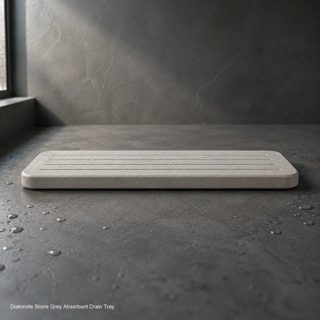 Stone grey diatomite drain tray on dark shower ledge, low side view showing slim edge and drainage channels.