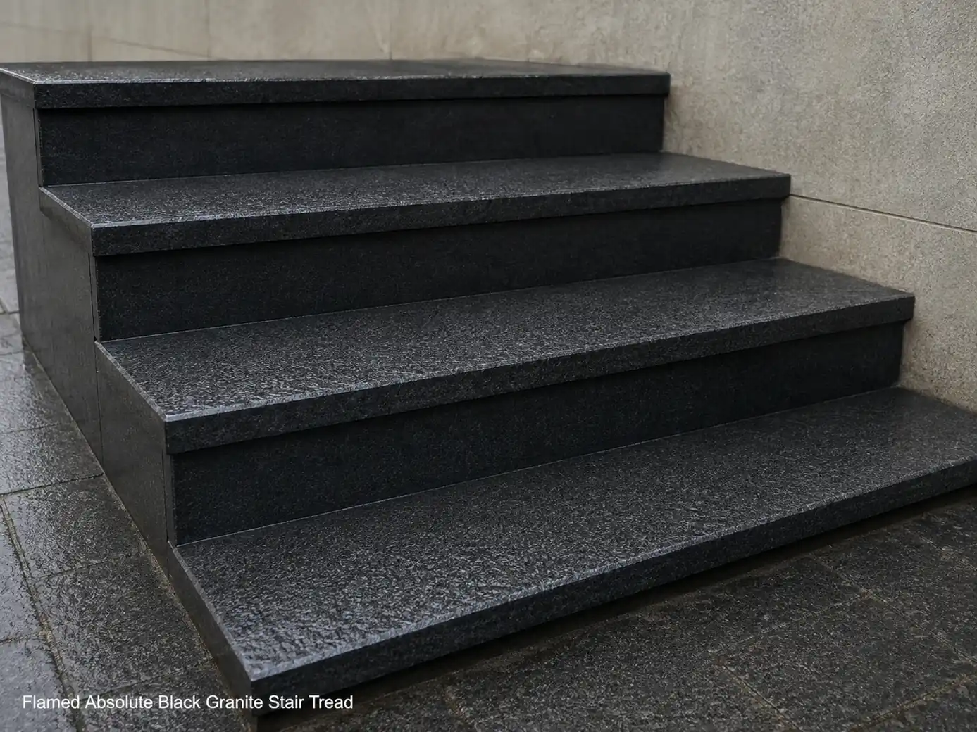 Damp flamed black granite steps photographed low from the side in soft overcast exterior light