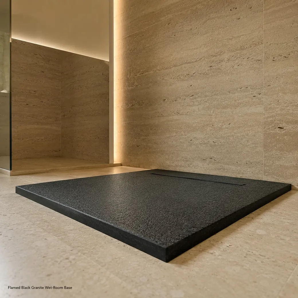 Low entrance view of black granite shower base with flamed texture, linear drain and 3 cm perimeter.