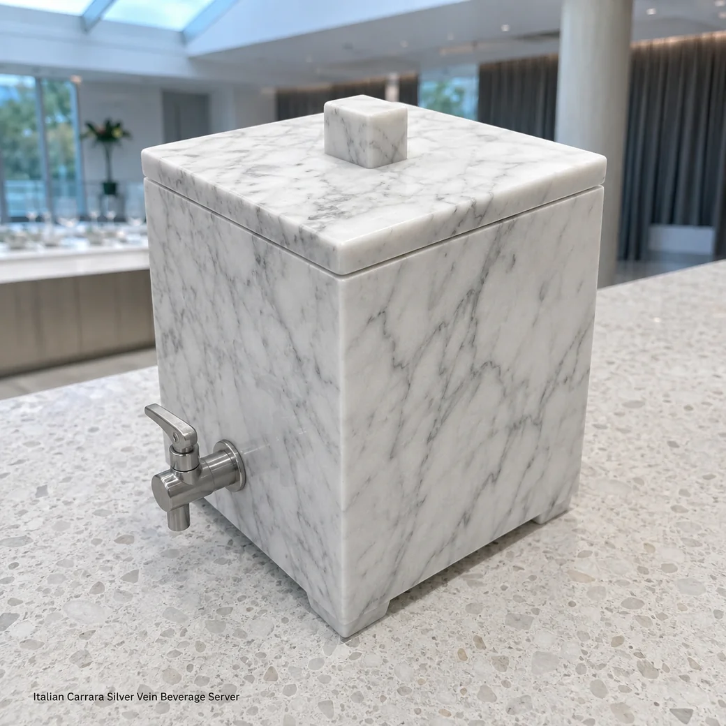 Carrara drink dispenser on pale terrazzo, high rear view showing lid, side veining and stainless tap.