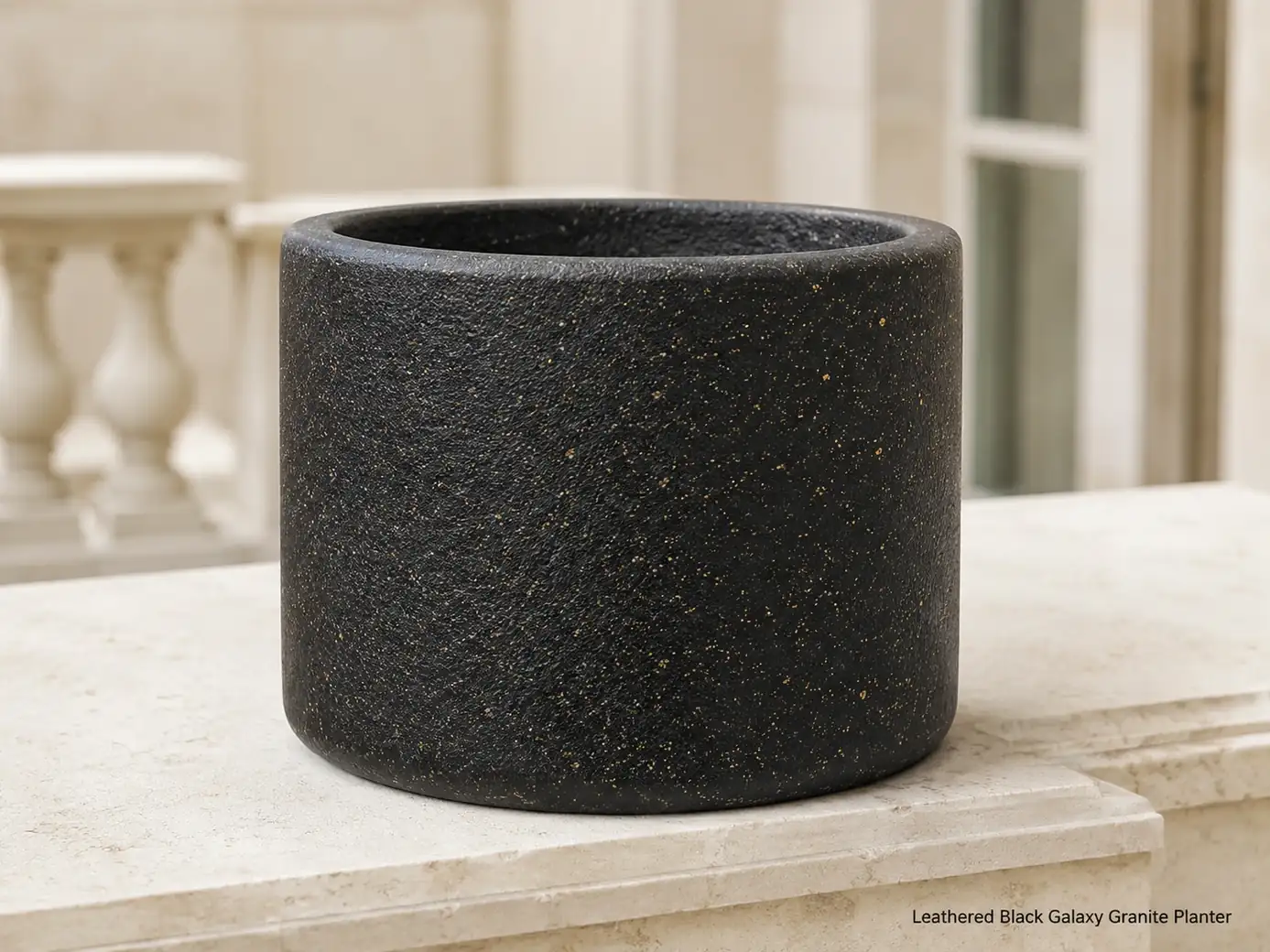 Empty Black Galaxy granite planter photographed low on a pale limestone balcony in indirect daylight