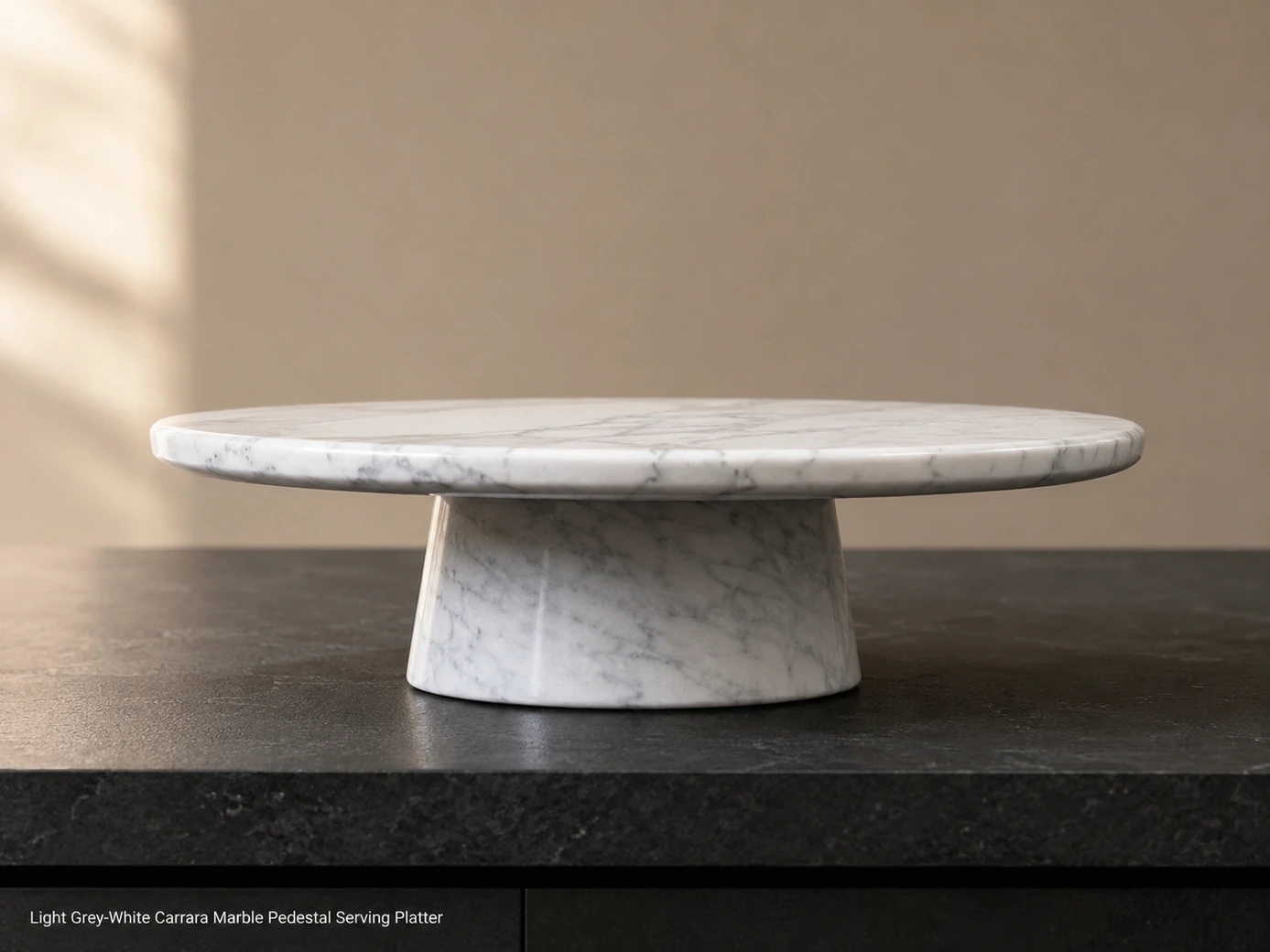 Side-profile Carrara marble serving platter on charcoal buffet, showing polished edge, low pedestal and grey-white veins.