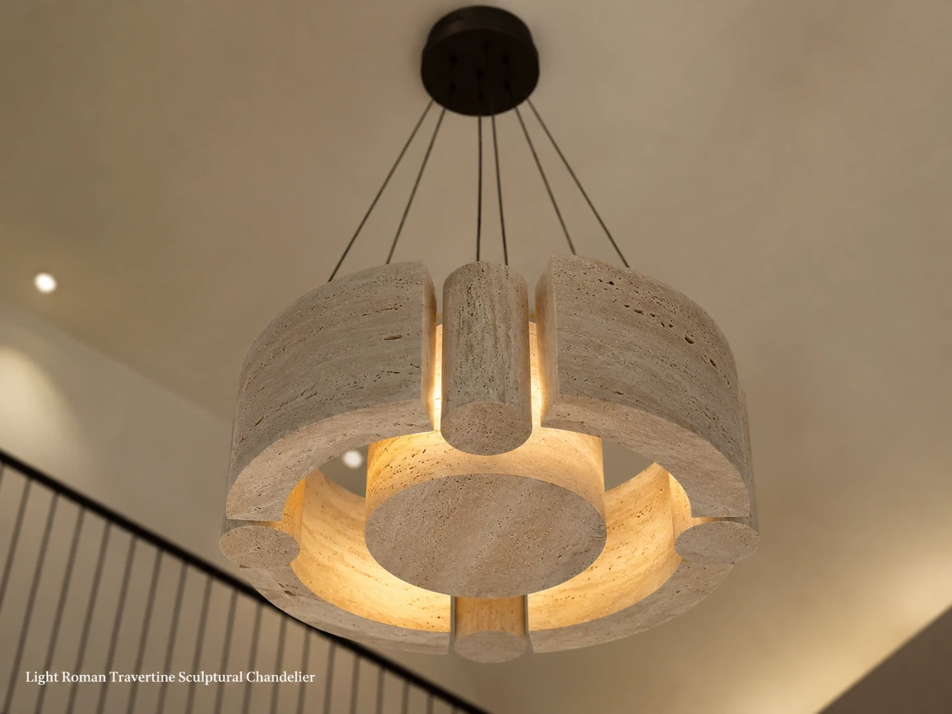Roman travertine chandelier viewed from below in a double-height stair hall with concealed warm light