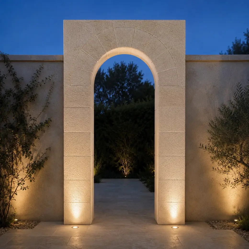 Front-view Limra limestone arch at blue hour with cream sandblasted stone and illuminated joints.