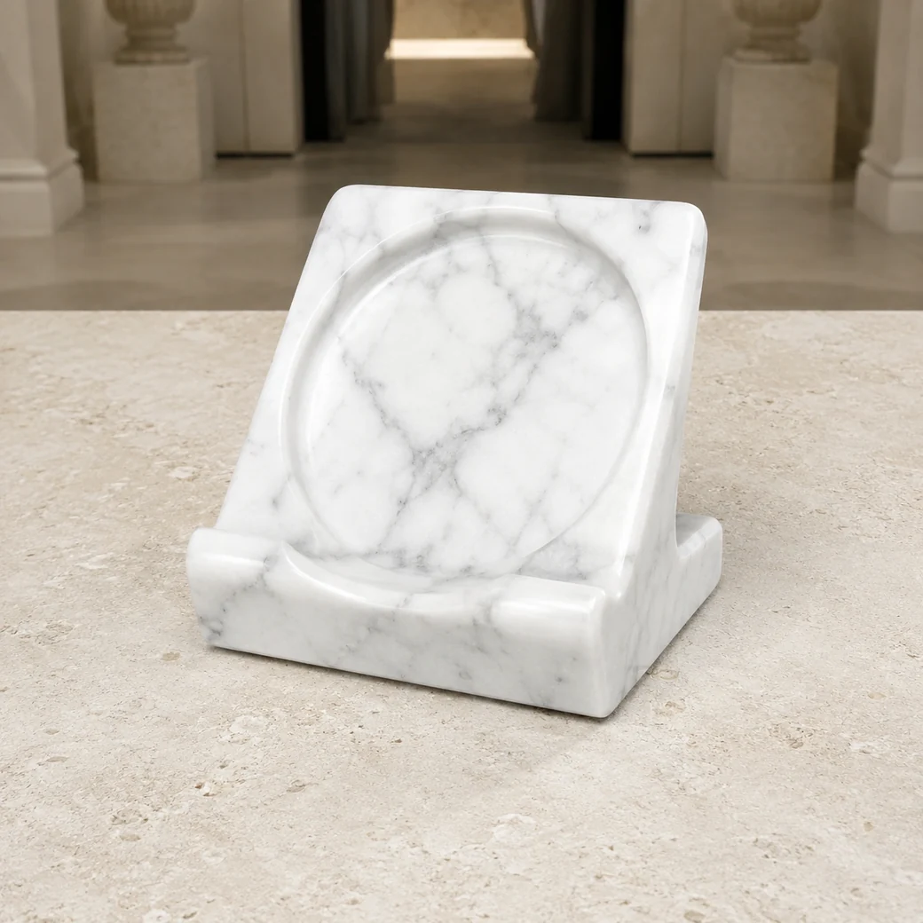 Polished Carrara plate stand on limestone pedestal, high front view exposing carved groove and silver veining.