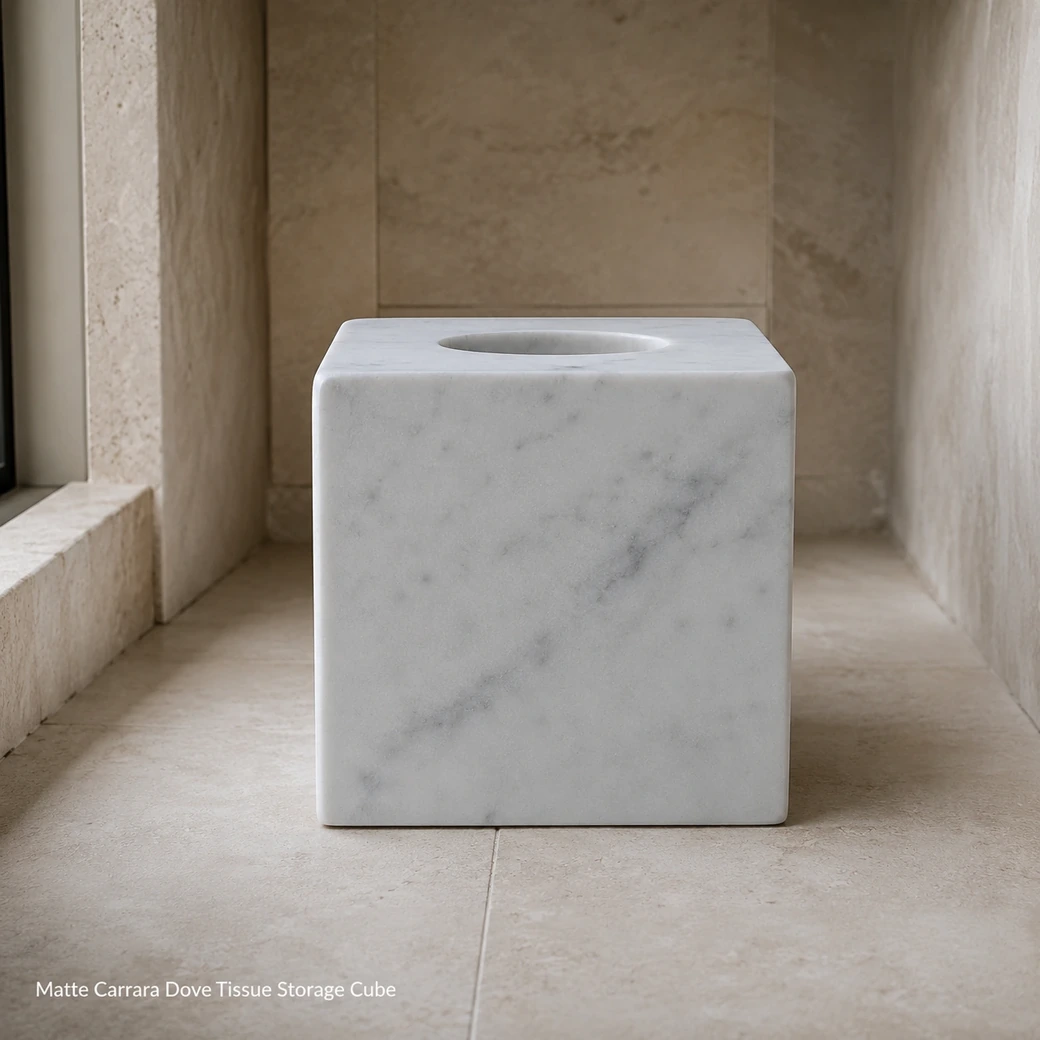 Dove white Carrara tissue holder on pale limestone floor, low front view emphasizing matte cube and oval opening.