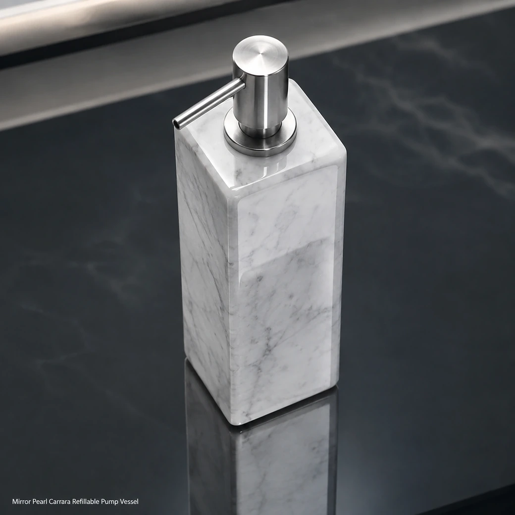 Pearl Carrara pump bottle on smoked glass, overhead view highlighting metal pump geometry and reflective white stone.