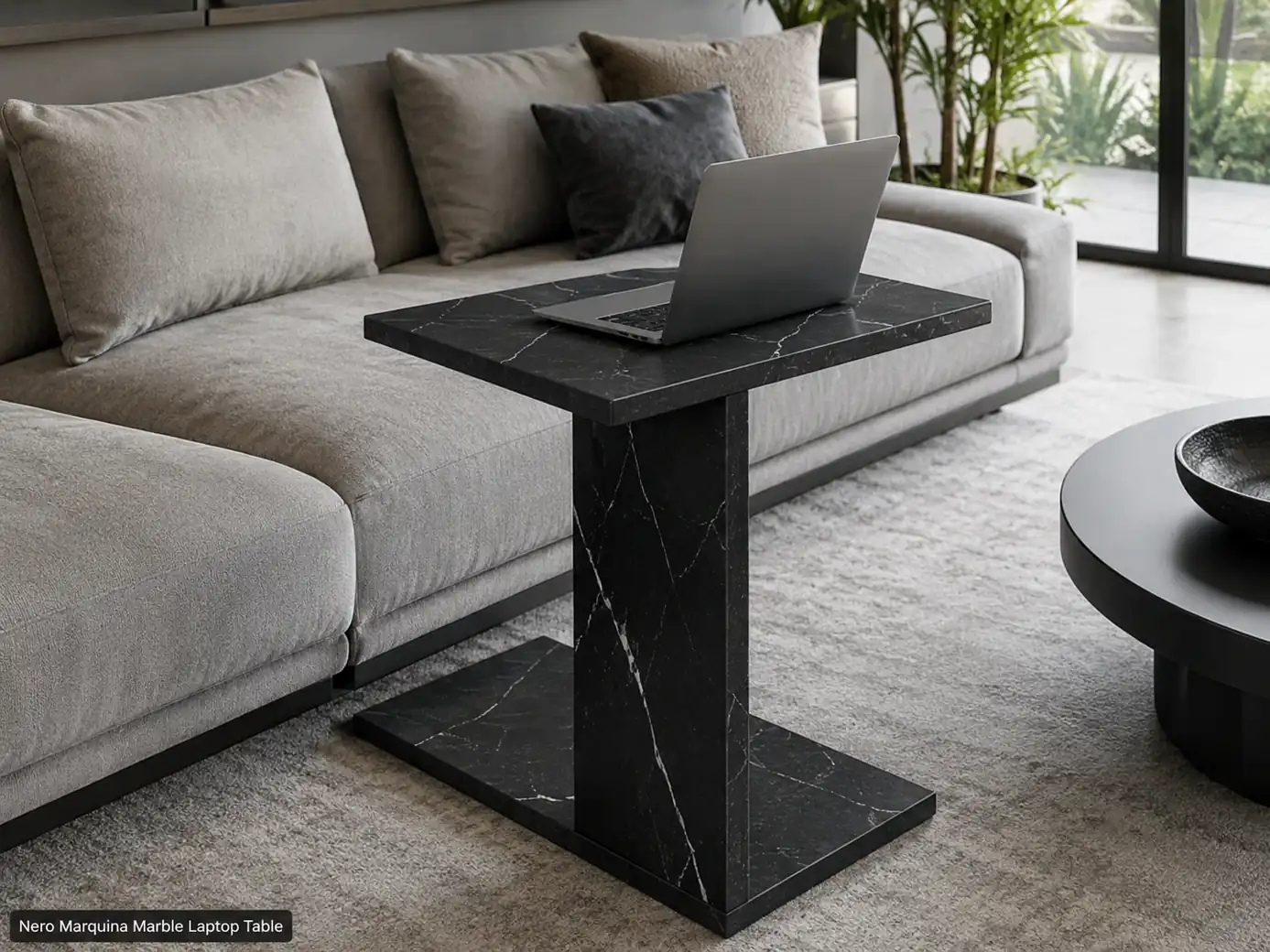 Honed Nero Marquina laptop table sliding beneath a sofa with an open laptop centred on the stone top.