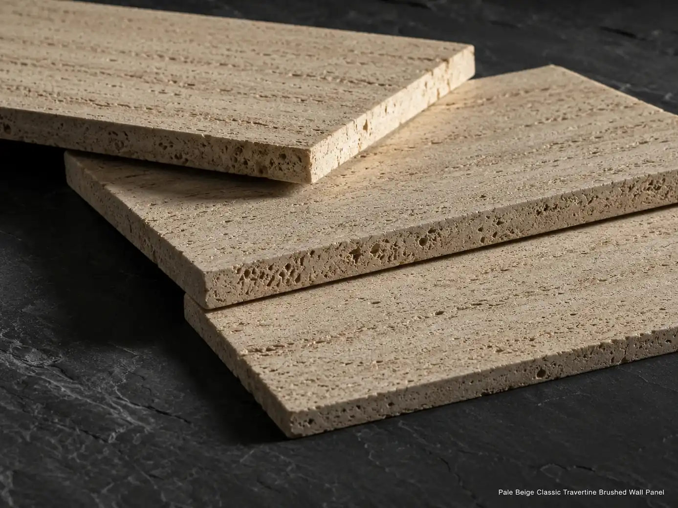Three pale beige travertine wall panels arranged on dark slate, highlighting open pores and brushed 2 cm edges.