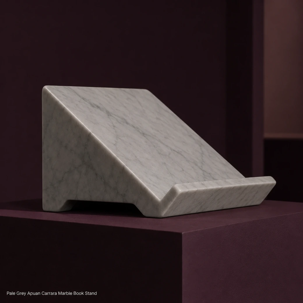 Pale grey Apuan Carrara book stand on plum pedestal, low side profile showing angled support and velvet-satin finish.