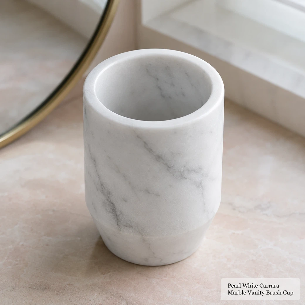 Pearl white Carrara vanity brush cup on blush surface, top-biased view showing empty cavity and matte grey veining.