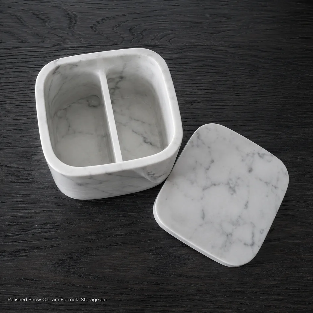 Snow white Carrara formula jar on smoked oak, overhead view with lid removed to reveal divided empty interior.