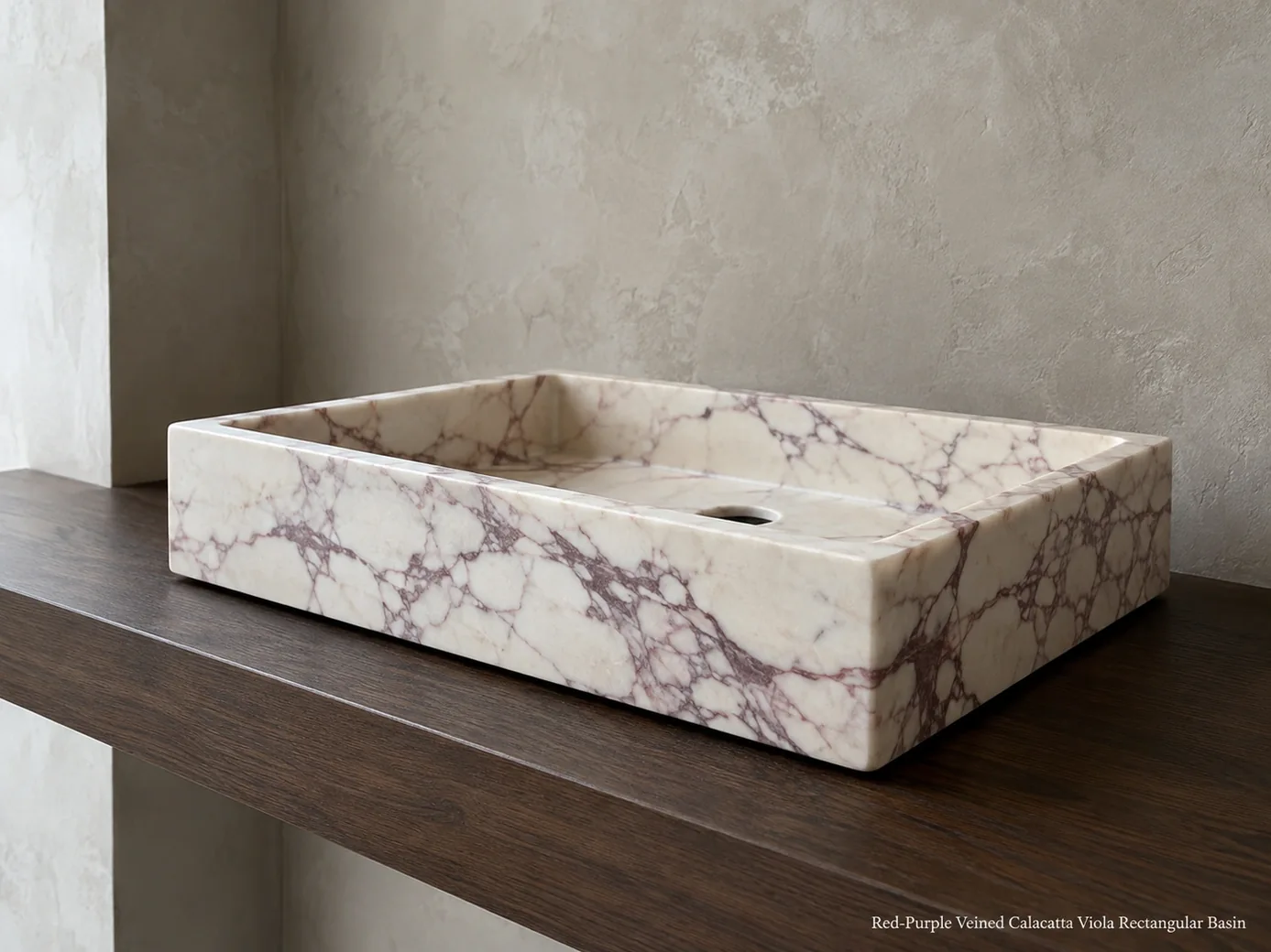 Low-angle Calacatta Viola rectangular basin on dark walnut, showing red-purple veins and crisp matte stone edges.