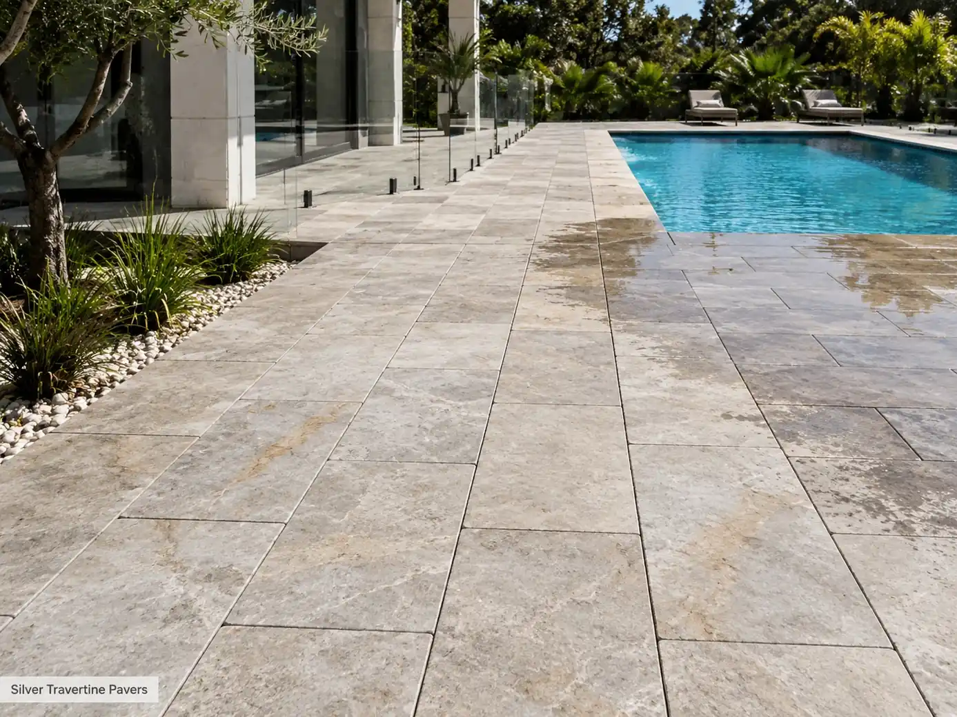 Silver travertine pavers around a modern pool with tumbled edges, beige veining and textured surface