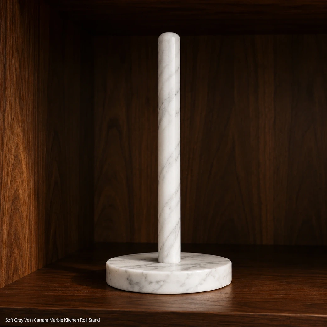 Carrara kitchen roll stand on deep walnut shelf, low front view showing soft grey veins and eggshell-honed base.