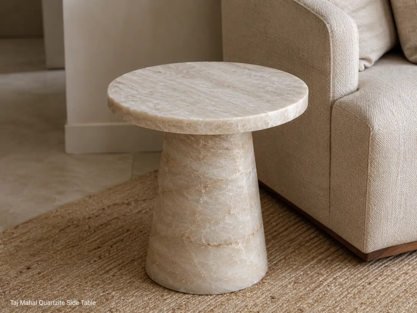 Brushed Taj Mahal quartzite side table with warm cream stone, soft gold veining and sculptural pedestal