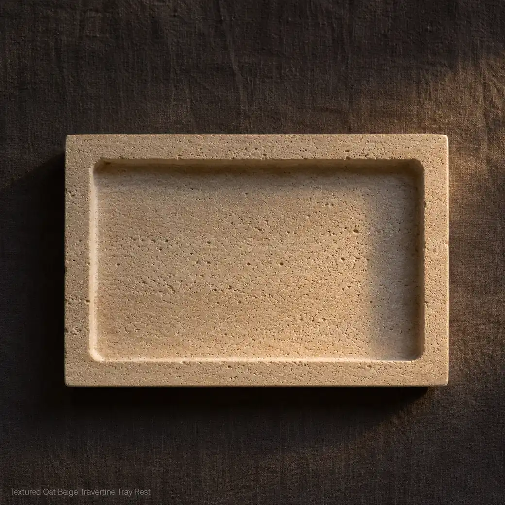 Oat beige travertine tray rest on dark linen, overhead view showing recessed center and fine Arenado texture.