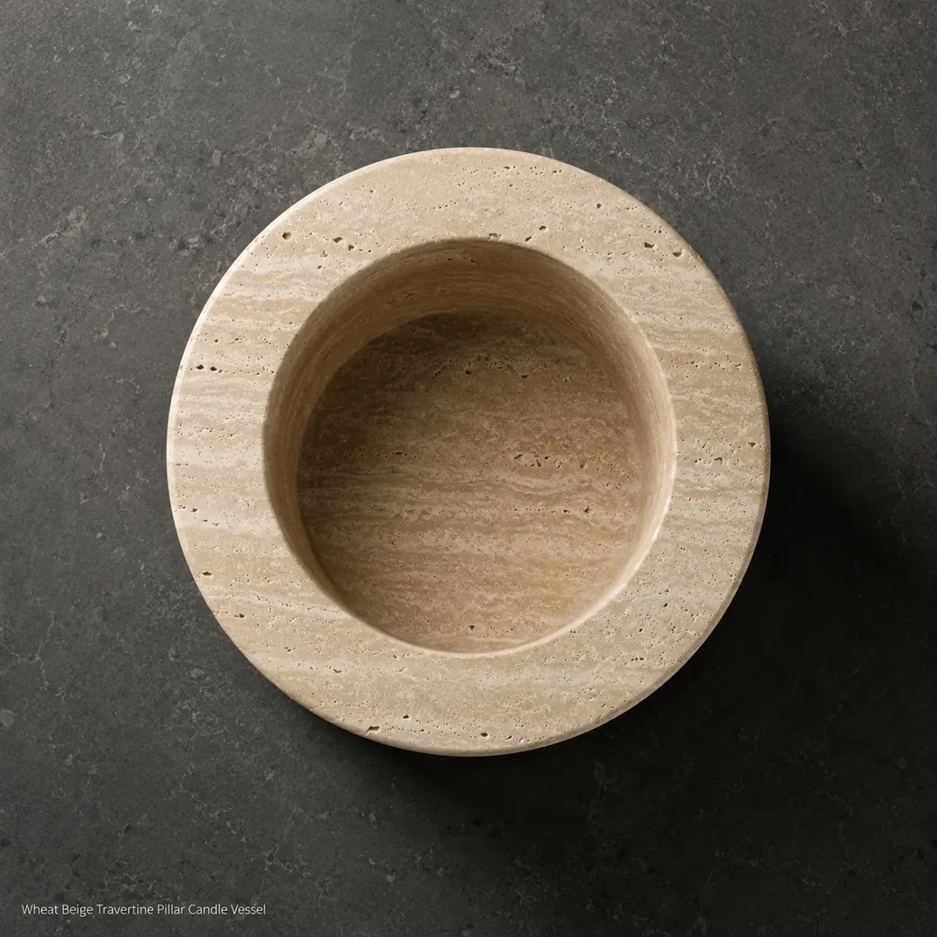 Wheat beige travertine candle holder viewed directly overhead on deep charcoal limestone