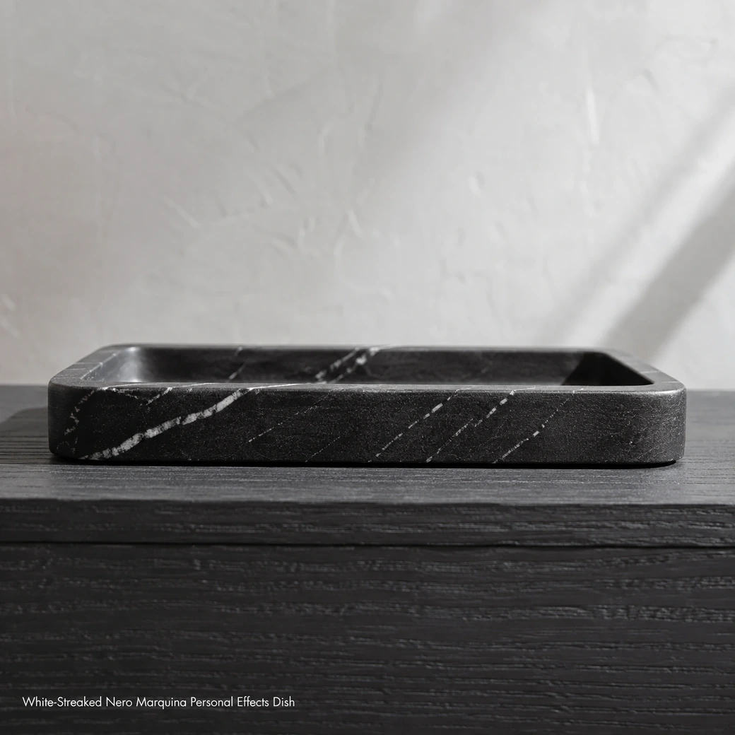 Low end-on Nero Marquina valet tray on charcoal oak with velvet black stone and fine white streaks.